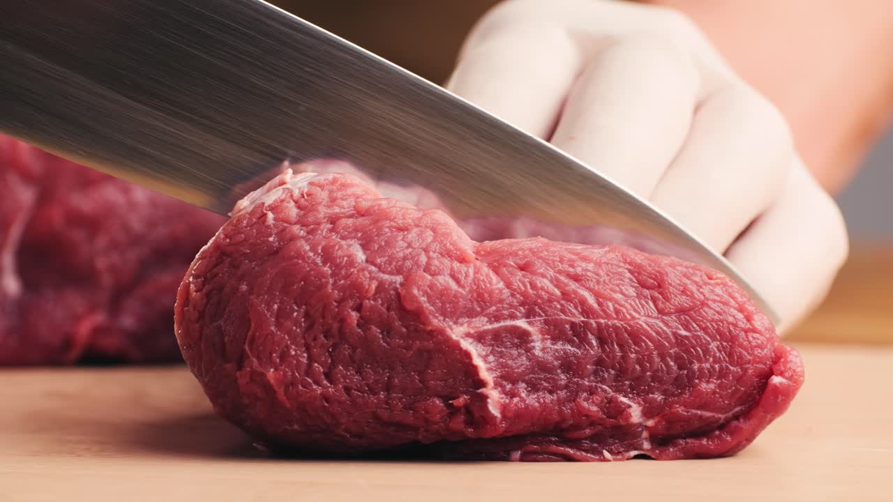 Chef Cutting Raw Steak