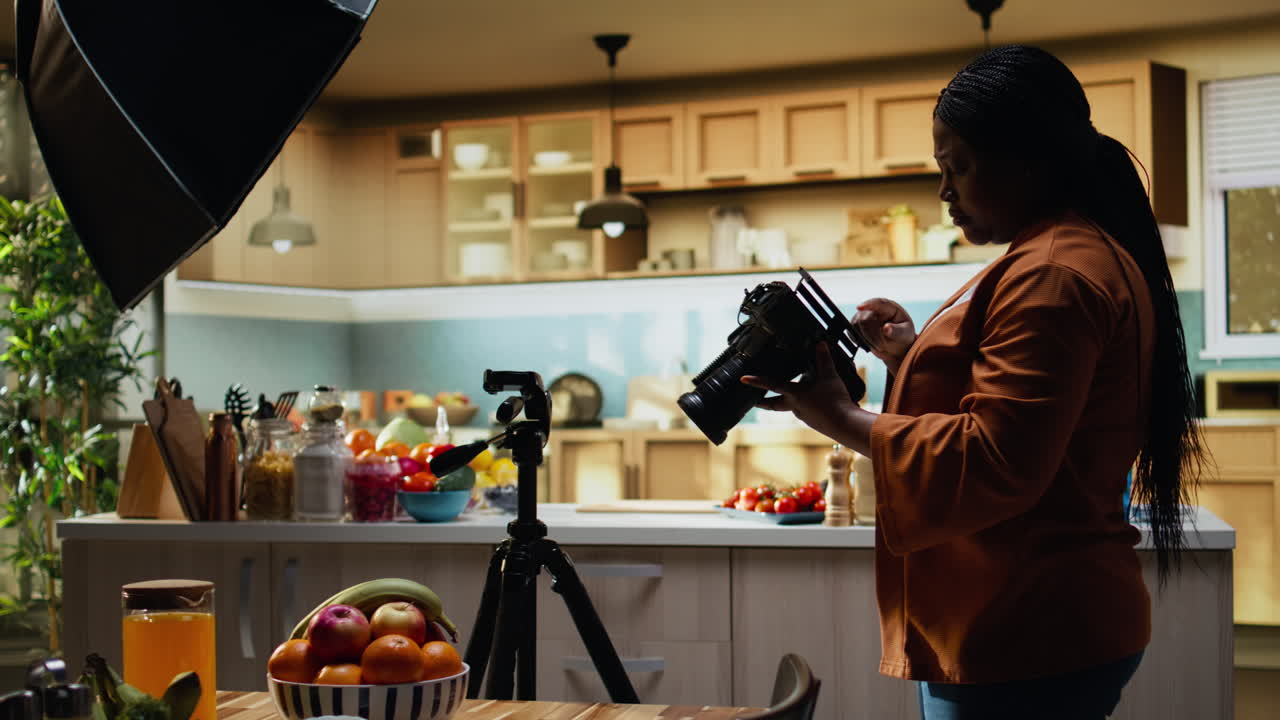 Influencer afroamericana che sistema l'attrezzatura della fotocamera dietro le quinte