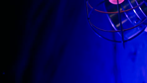 old metal loft chandelier with yellow electric bulb sways in nightclub