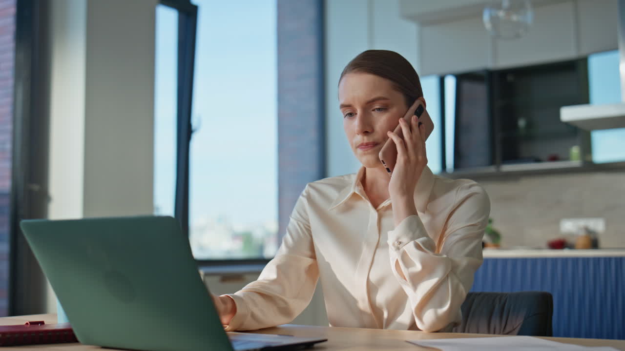Donne d'affari che si lamentano di una telefonata cellulare che esaminano i documenti a casa