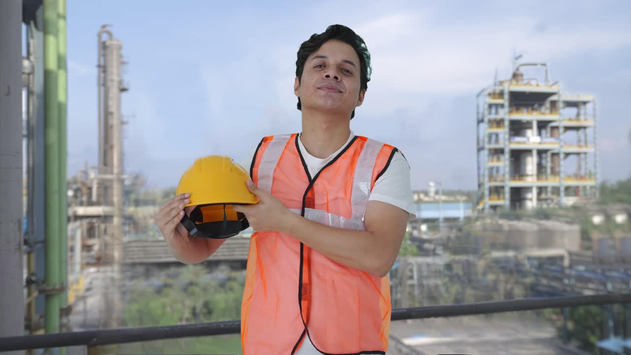 trabajador de construcción indio feliz quitando el casco