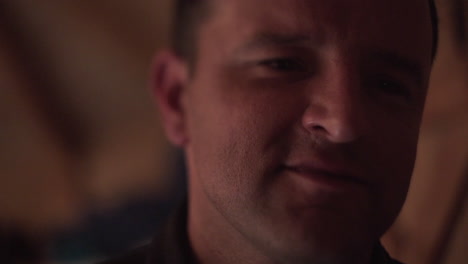 static close up fhd shot of a man looking in front of him and remembering someone he knew and loved, smiling about a happy memory, while winking with his eyes