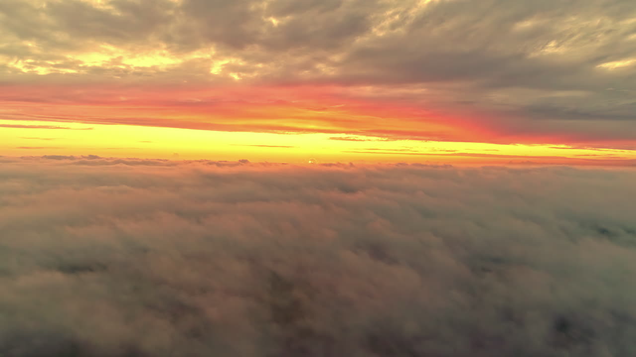 Vista aerea al tramonto di un orizzonte giallo sopra un'inversione nuvolosa - fenomeno meteorologico.