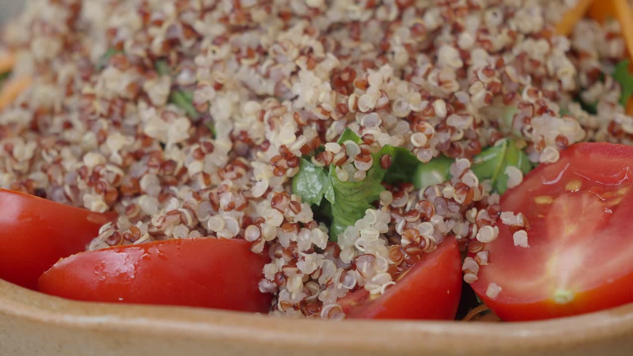 A close-up shot of a healthy quinoa salad with fresh tomatoes and greens