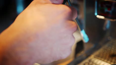close up of barista frothing hot milk to add to coffee