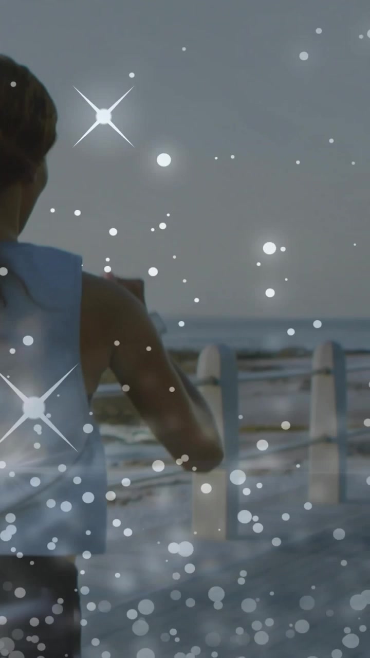 Vertical video: Woman entering left, passing railing holding phone, sparkles overlaying for fitness