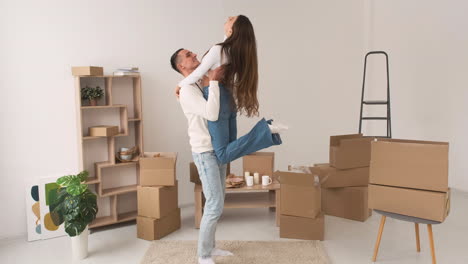 Vista-Frontal-De-Una-Joven-Pareja-Feliz-Descalza-Bailando-Juntos-En-Una-Alfombra-En-Una-Casa-Nueva-1