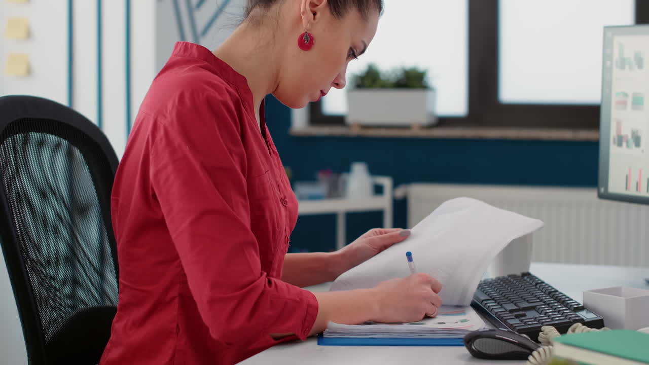 Female accountant taking notes on business documents