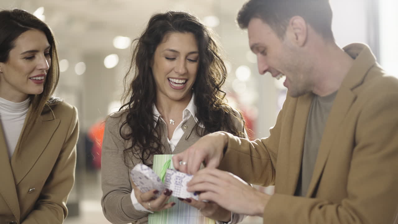 Friends happily unboxing and admiring a new watch while shopping
