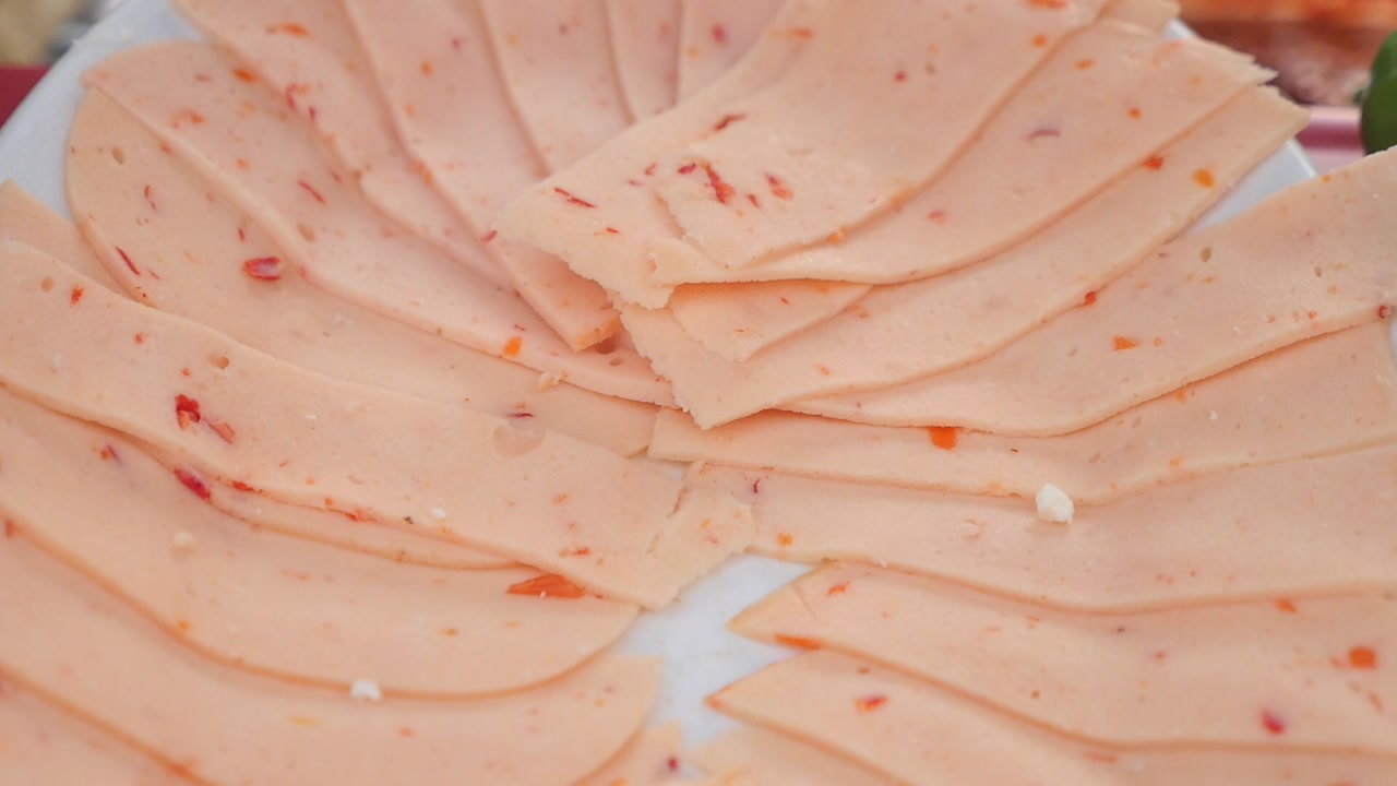 Close-up of Sliced Deli Meat with Red Peppers on a Plate