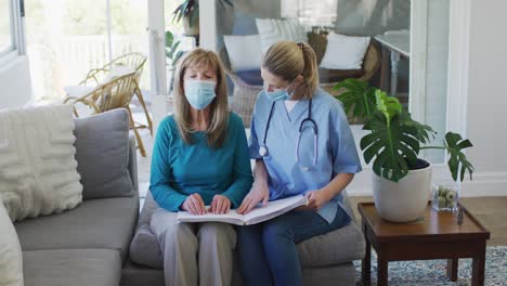 female health worker assisting senior woman to read braille book