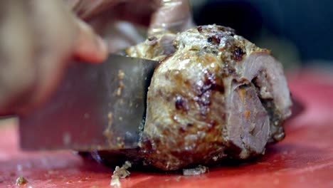 mano con cuchillo cortando carne a la parrilla. cerrar