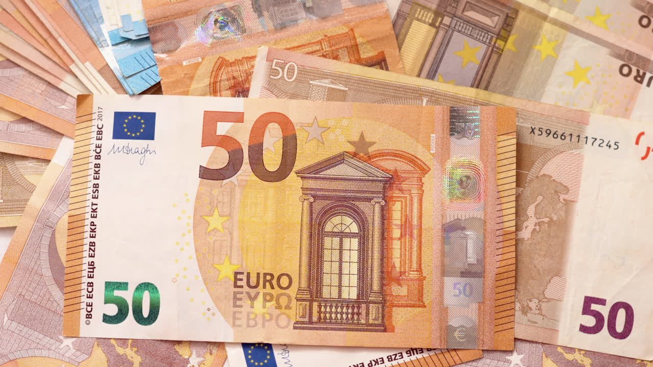 Multiple 20, 50 and 100 euro bills on a surface