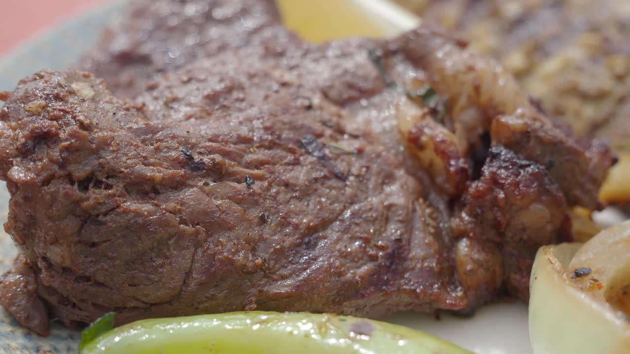 Primer plano de filete a la parrilla servido con cebolla y pimiento