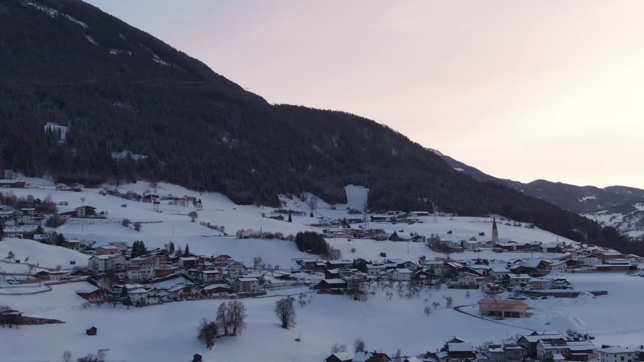 Aerial view of houses in the mountains in Austria in snow.