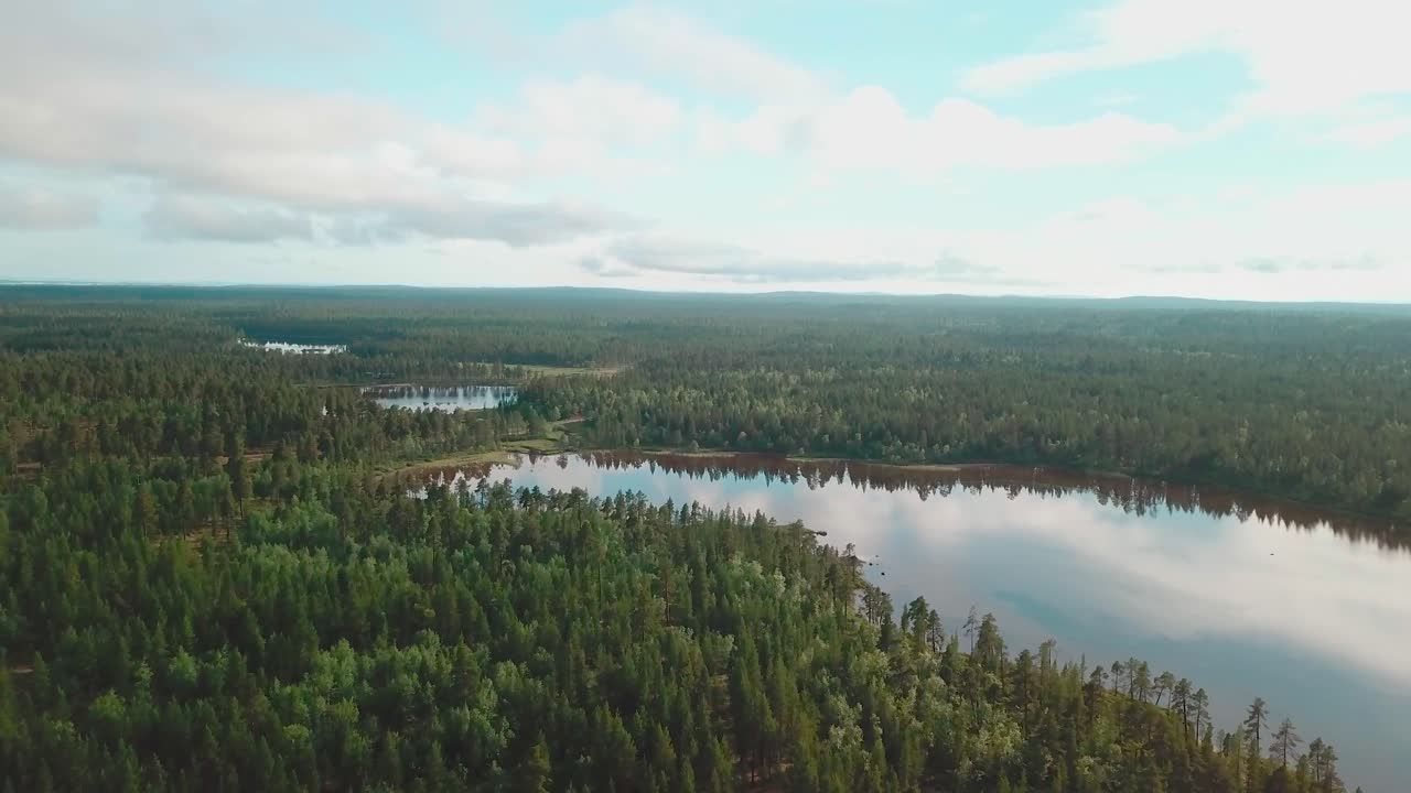 핀란드 북부의 숲과 호수 위로 전방 드론 촬영