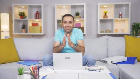 Home-office-worker-man-looking-at-camera-clapping-and-getting-excited.