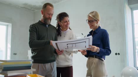 propietarios que revisan los planos de la casa con el arquitecto o el agente