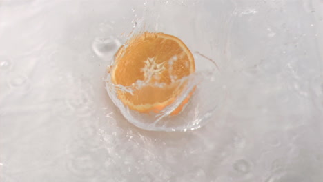 Orange-falling-into-water-in-super-slow-motion