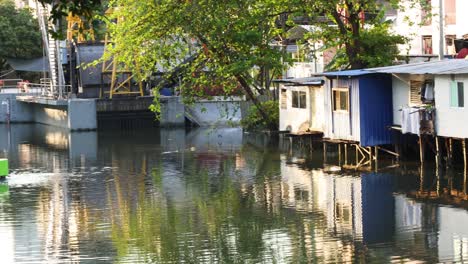 stilt houses reflected in tranquil water over time