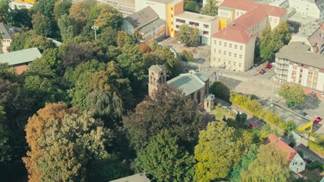 Una-Iglesia-Rodeada-De-árboles-En-Una-Zona-Urbana,-Luz-Del-Día,-Vista-Aérea