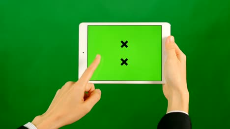 mujer de negocios usando una tableta de pantalla verde en blanco sobre un fondo verde.