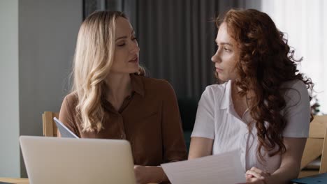 zwei frauen arbeiten zusammen im home office an einem neuen projekt.