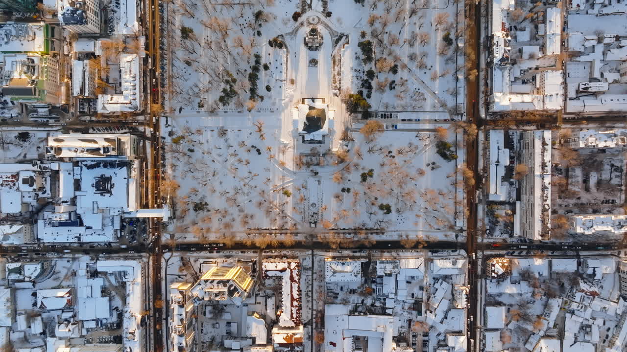 Aerial drone top view of the Bell tower and the Metropolitan Cathedral of Christ's Nativity. City center covered in snow at sunset in Chisinau, Moldova