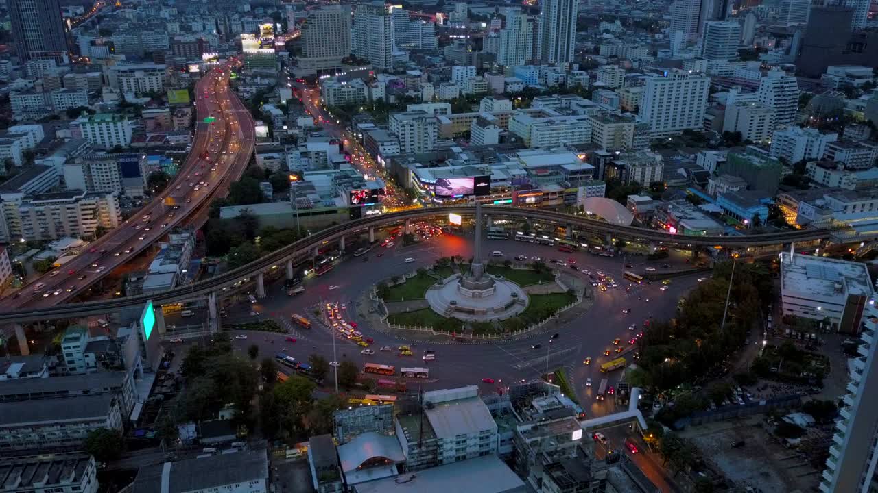 vista aérea de la enorme rotonda y los semáforos en el monumento a la victoria al anochecer en bangkok, tailandia
