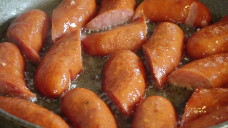 slices of dried sausage sizzle in a hot pan, releasing savory aromas