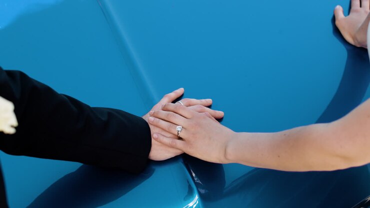 Couples hands on blue car