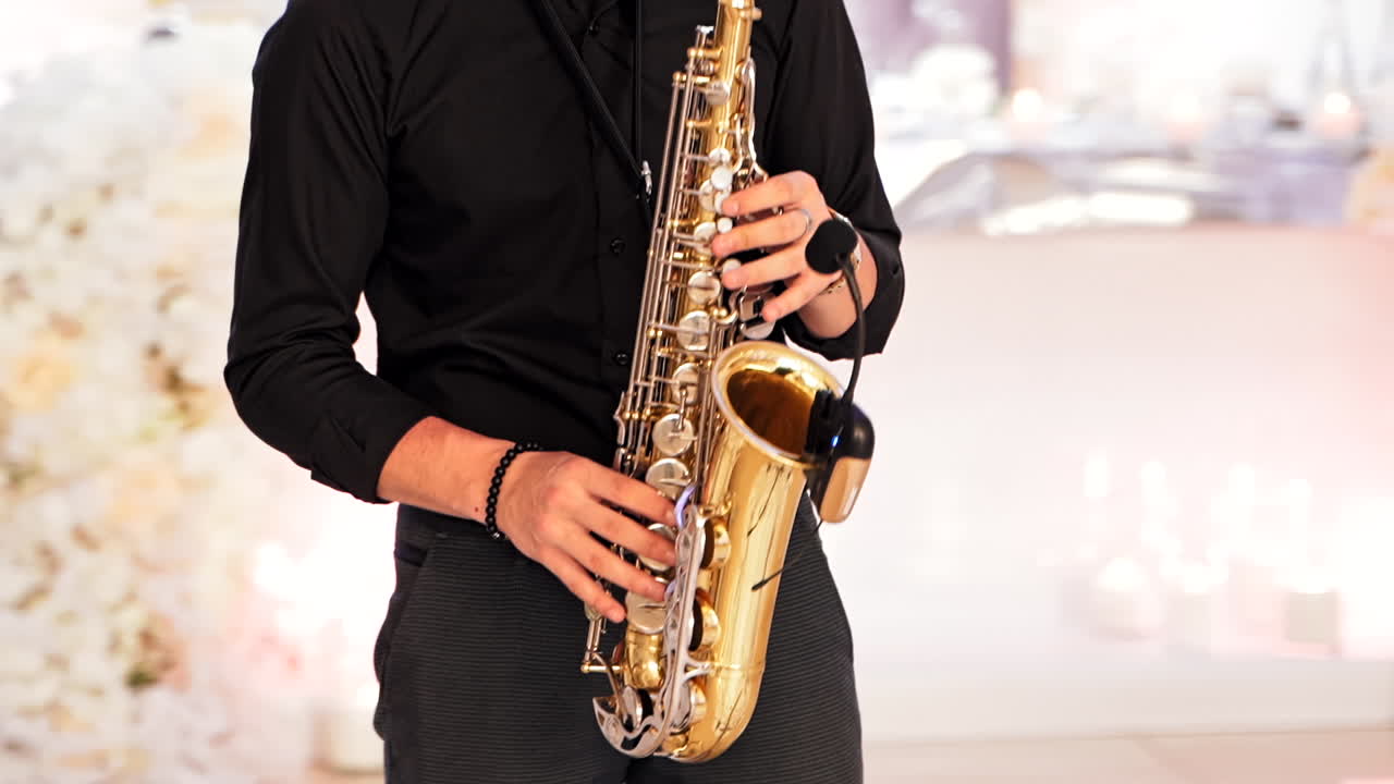 Man play on axophone with microphone. Close up of saxophonist playing on his instrument