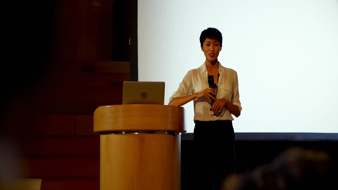 Young Asian businesswoman speaking in business seminar in auditorium 4k