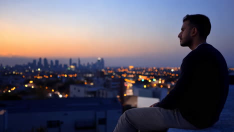 man contemplating city sunset