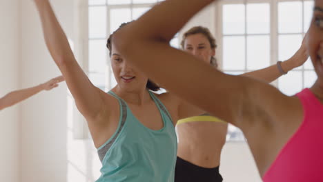 Glückliche-Kaukasische-Frau-Tanzt-Eine-Gruppe-Gesunder-Menschen,-Die-Das-Training-Genießen-Und-Choreografie-Tanzbewegungen-üben-Und-Spaß-Im-Lebhaften-Fitnessstudio-Haben