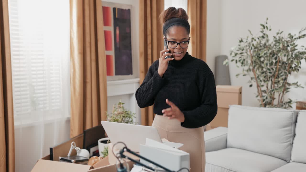 A woman has moved into a new apartment, buys furniture online, searches for furnishing stores on laptop, calls a hotline on the phone to find out more information