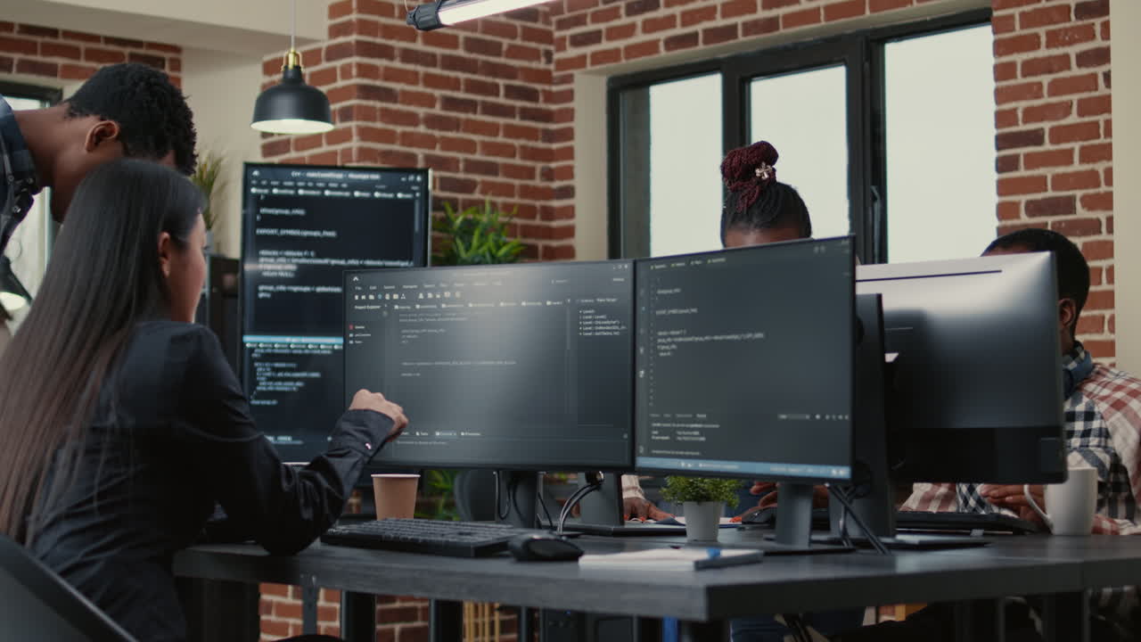 Mixed team of programmers analyzing source code pointing at screens comparing algorithm