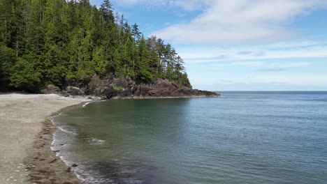 Aerial-Panning-Shot-Over-a-Beach-at-Moresby-Island-with-Low-Shot-Over-Calm-Water