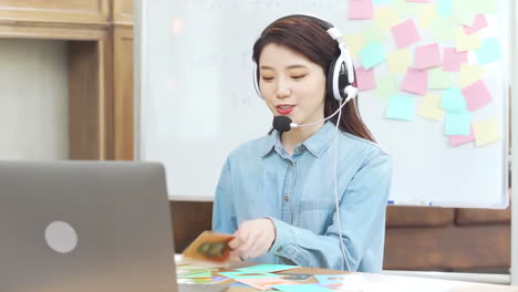 Mujer-Agente-De-Telemarketing-De-Servicio-Al-Cliente-Positiva-En-Casa-Haciendo-Una-Consulta-Por-Computadora-Con-Auriculares