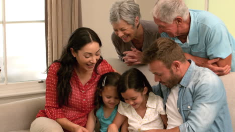 Familia-Multigeneracional-Usando-Tableta-En-El-Sofá