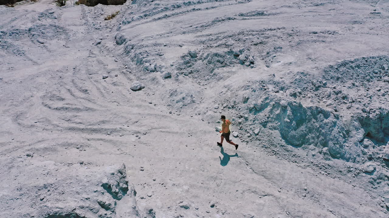 Active runner jogging outdoor. Aerial view of athletic young man running in the nature
