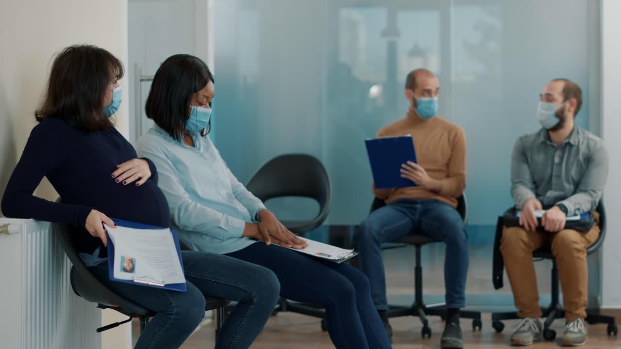 Pregnant woman waiting in queue with diverse group of candidates