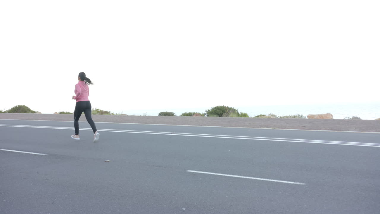 Running on road, woman in athletic wear exercising outdoors near mountains, copy space