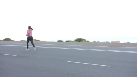 running on road, woman in athletic wear exercising outdoors near mountains, copy space