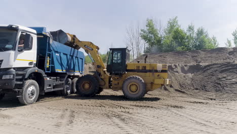 excavator loading dump truck with sand/gravel/dirt