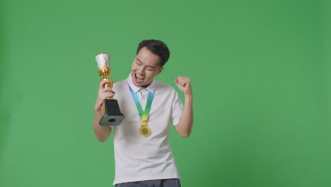 man celebrating victory with a trophy and medal