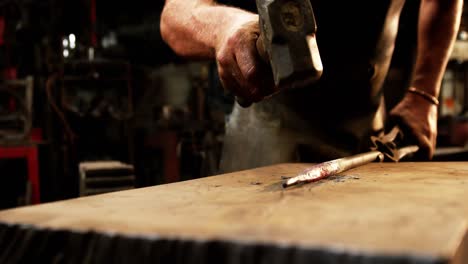 Mid-section-of-blacksmith-working-on-a-iron-rod