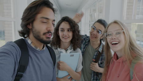happy students taking a selfie in a university hallway