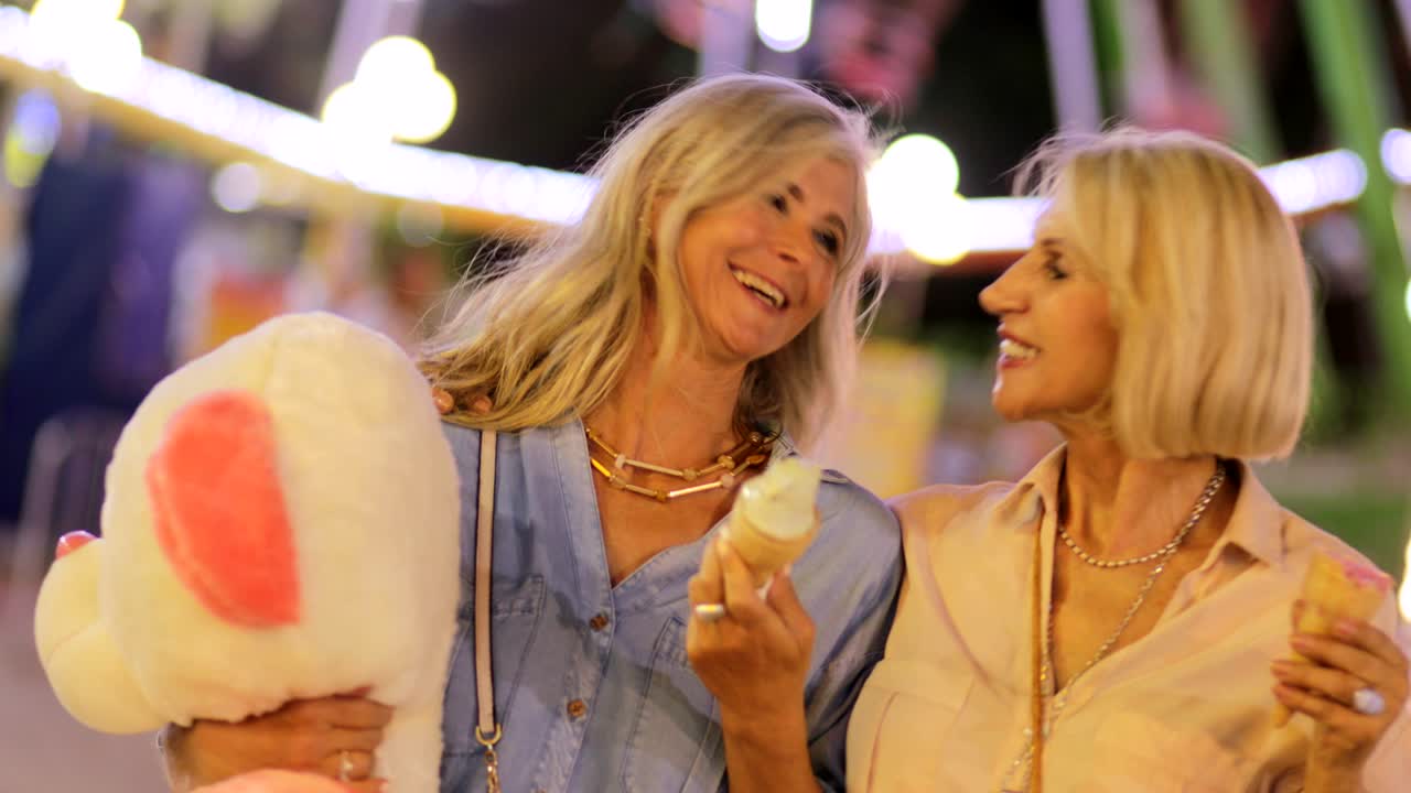 고령 여성들이 아이스크림을 먹고 파니페어에서 재미를 느끼고 있습니다.