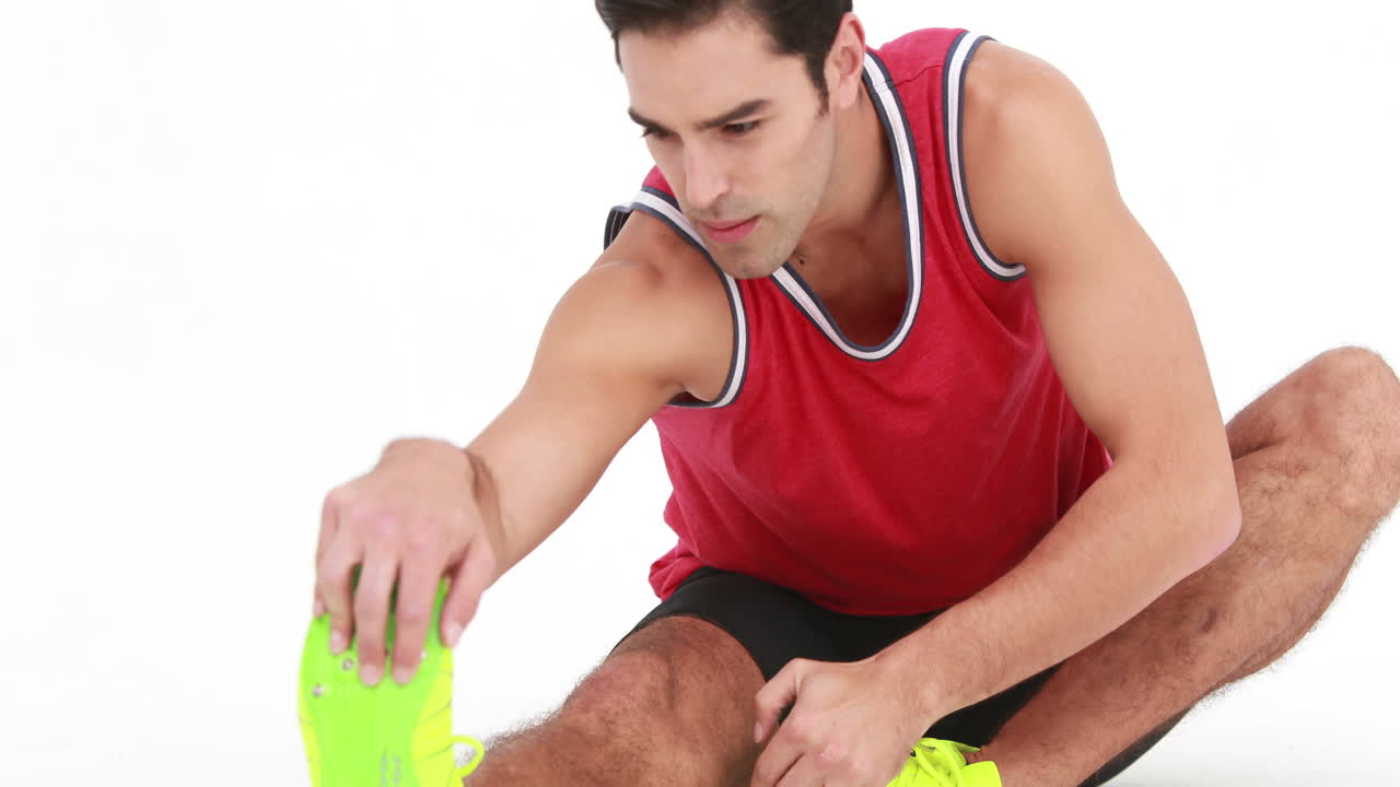 Atleta sorridente che allunga le gambe